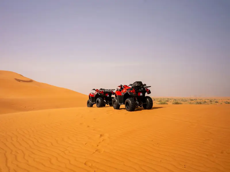 Illustrative desert activity scene with two parked quad bikes